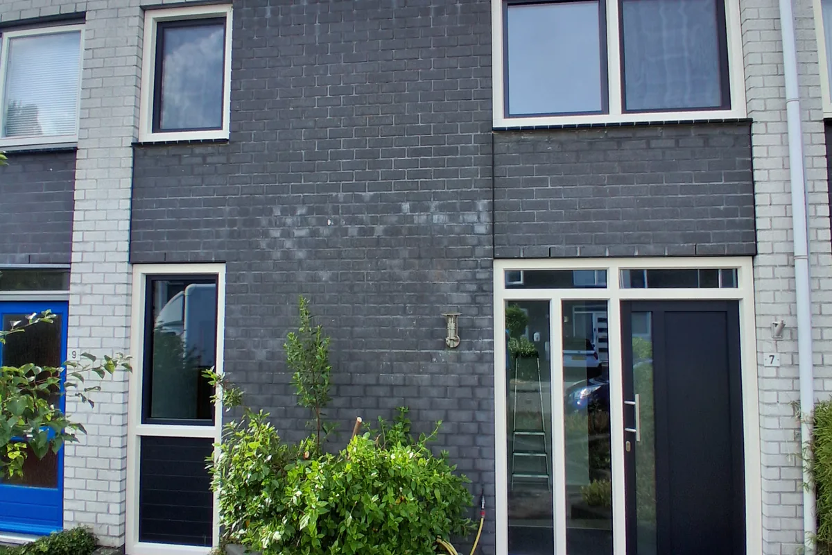 Gevel met nieuwe witte kunststof kozijnen en een antraciet voordeur van KDB Kozijnen